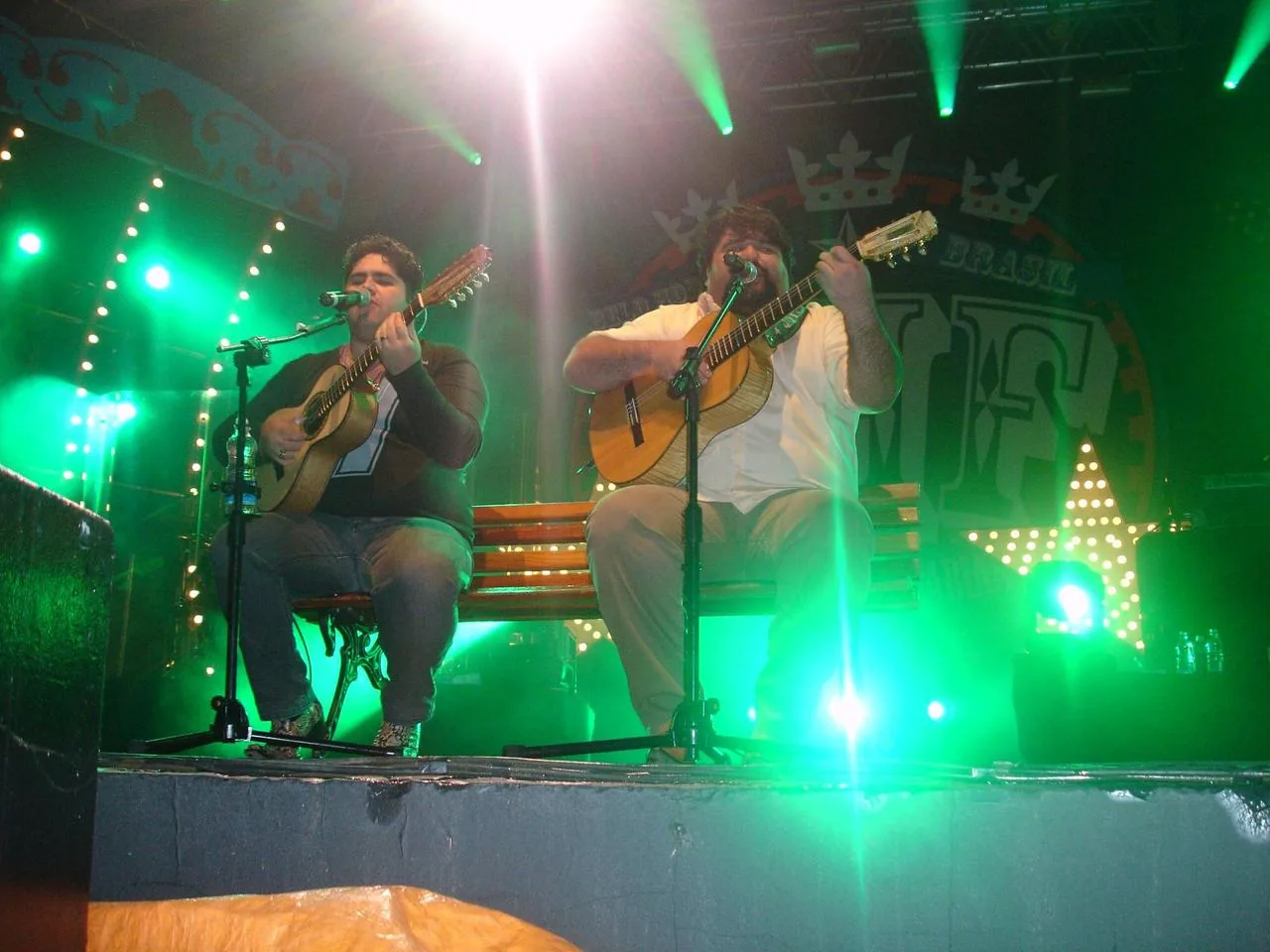 Dupla se apresentando em palco iluminado